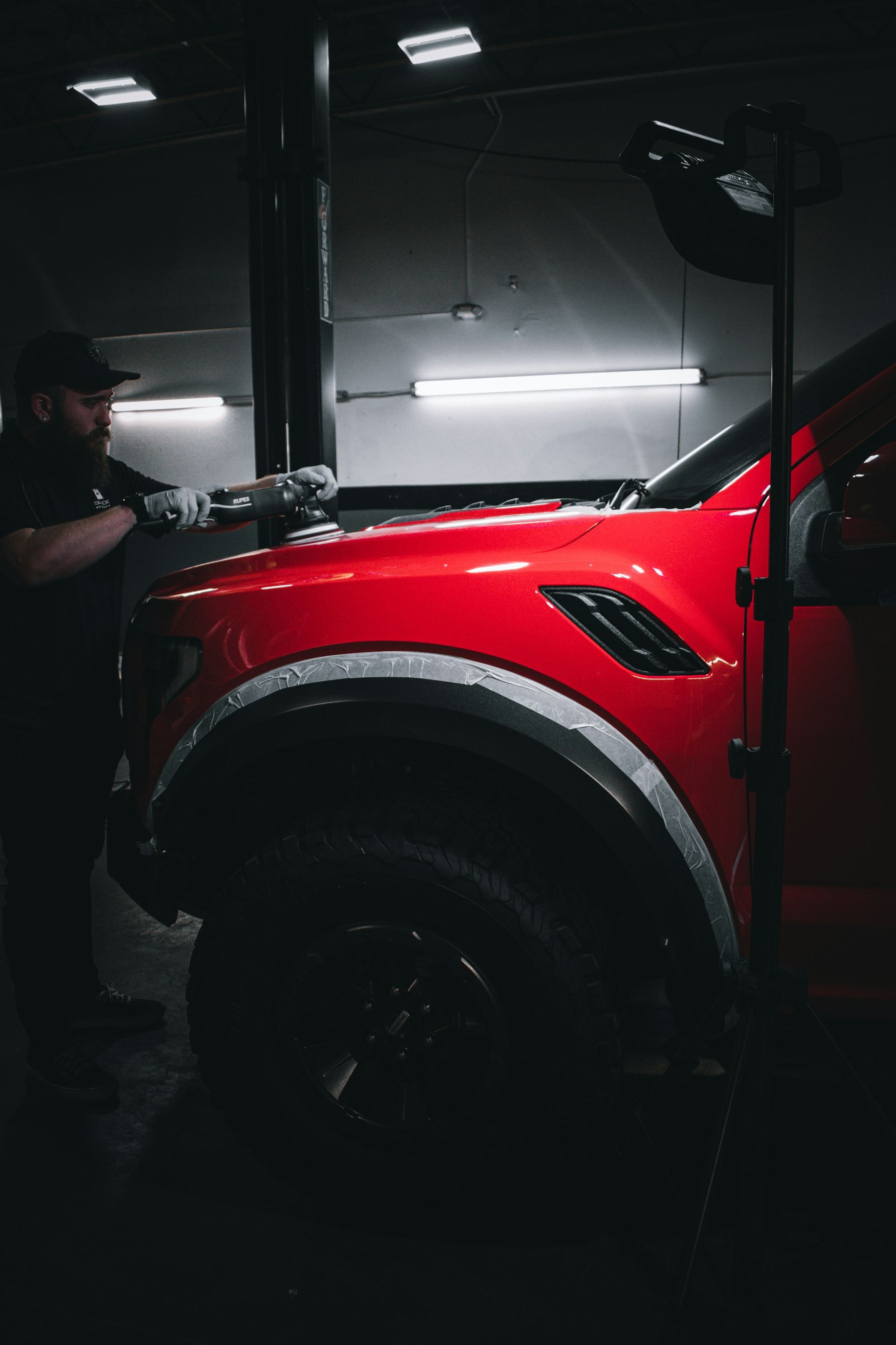 Technician machine-polishing a vehicle